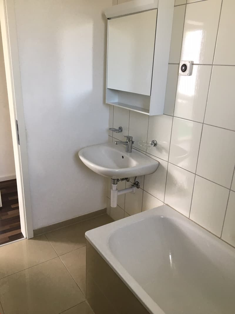 Modernes Badezimmer mit Lavabo, WC, Spiegelschrank und Badewanne