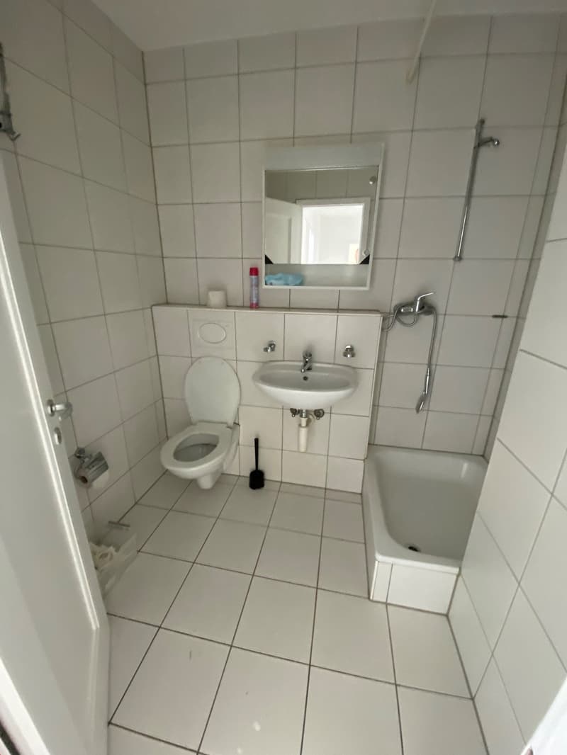 white tiled bathroom, sink, shower, toilet, mirror, bathtub