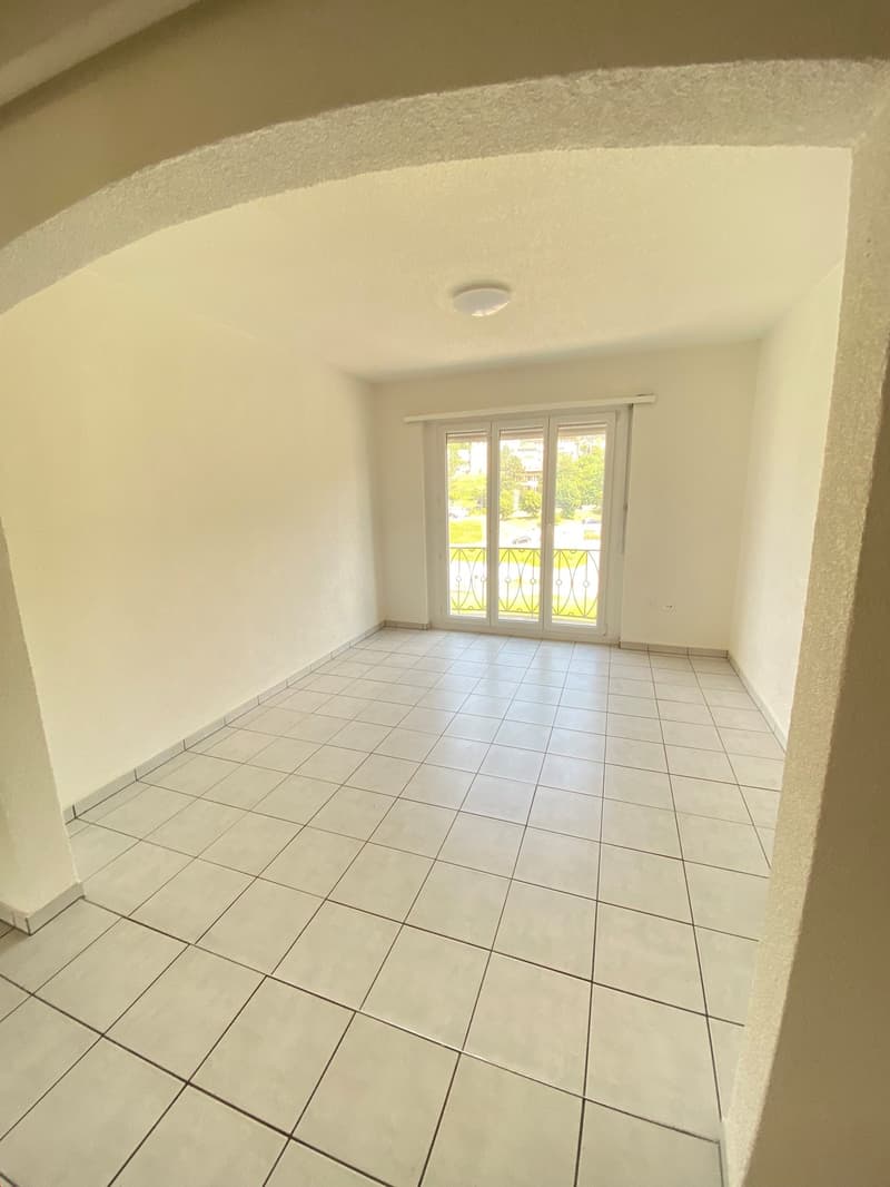 white tiles, ceiling light, glass door to balcony, empty room