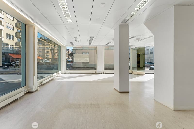 Empty room with large windows, white walls, white ceiling, white floor, pillars