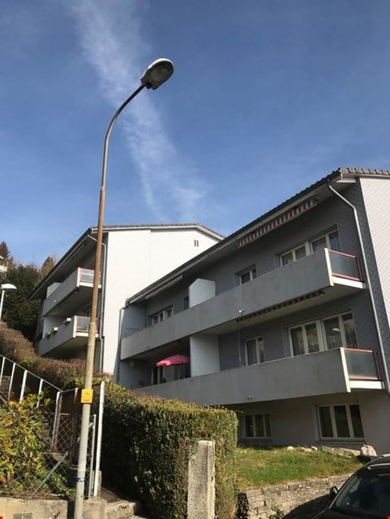 3 story building, balconies, windows, street light, car parked