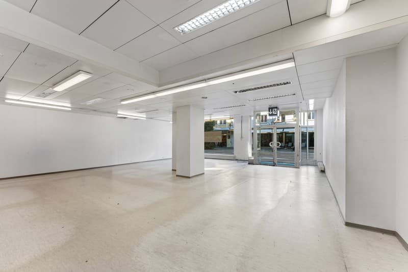 Empty room with white walls, white ceiling, white floor, glass door, and lights