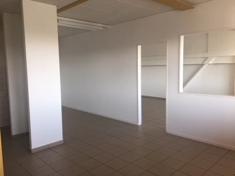 empty room with white walls, brown tiled floor, and built-in shelves
