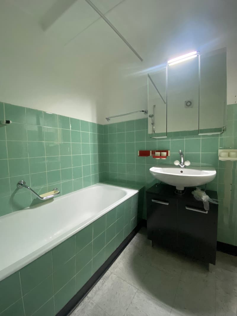 Bathroom: bathtub, sink, mirror, tiled walls, green tiles, white tile floor