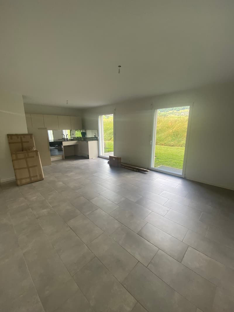 empty room, large windows, tiled floor, kitchen area with sink and faucets
