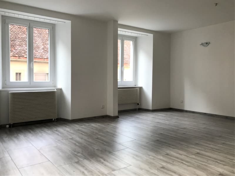 empty room, white walls, wooden floor, two windows, radiators