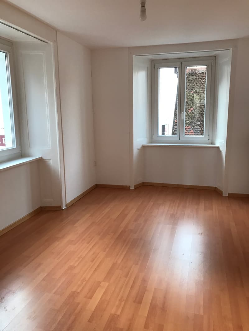 empty room, wooden floor, white walls, two windows, bright light