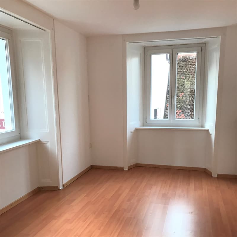 empty room, wooden floor, white walls, 2 windows, view of the outside