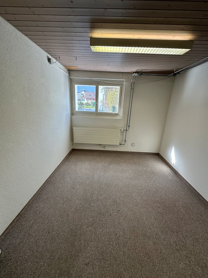 empty room, white walls, ceiling with wooden beams, window, radiator, carpeted floor