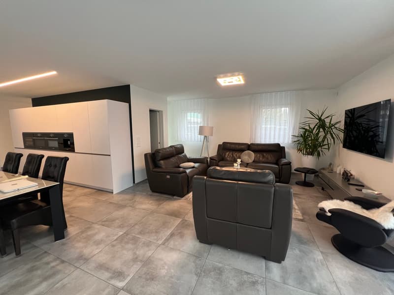 living room with 3 leather sofas, large table, tv, desk, lamp, plant, dining table and chairs