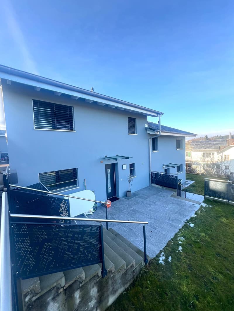 House with two floors, paved front yard, white doors, glass windows, staircase, metal railing, lawn