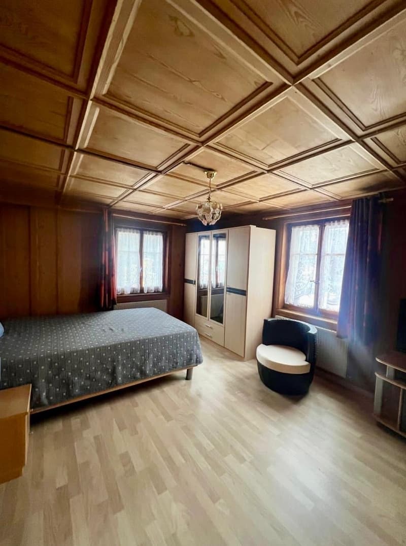 wooden ceiling, wooden floor, bed, chair, cabinet, chandelier, windows, curtains, radiator, TV