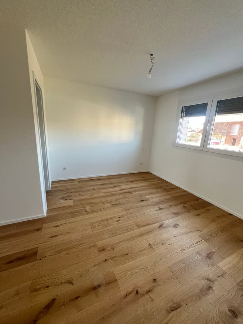 empty room, wooden floor, white walls, window, power outlet