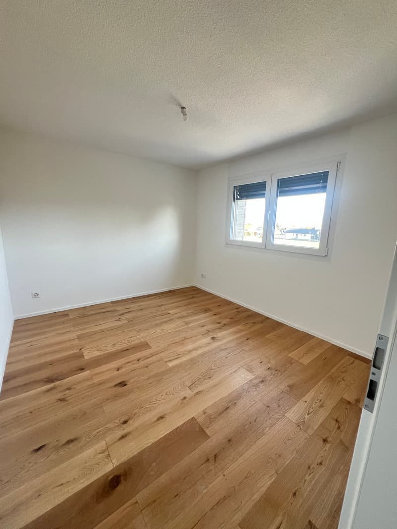 empty room, wooden floor, white walls, window, power outlet