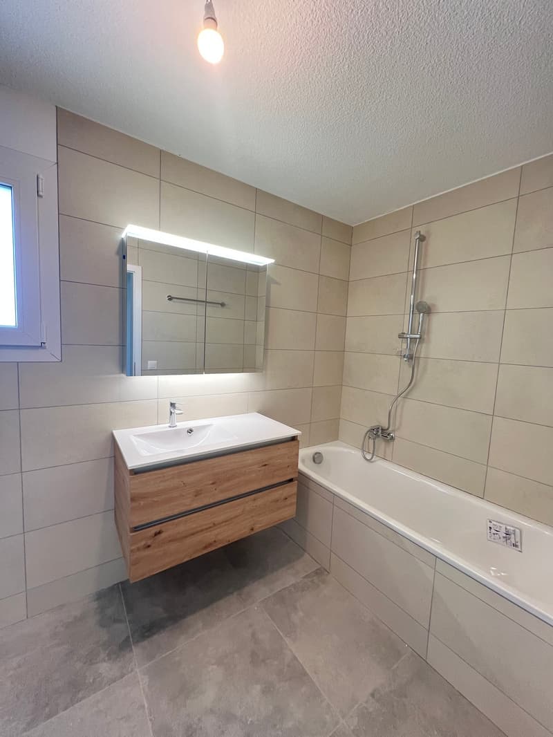 Bathroom with bathtub, sink, mirror, and shower head