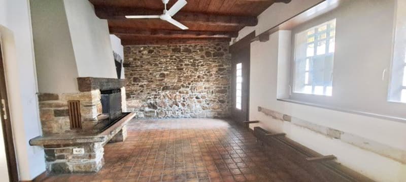Stone wall, fireplace, wooden ceiling, tiled floor, bench, window