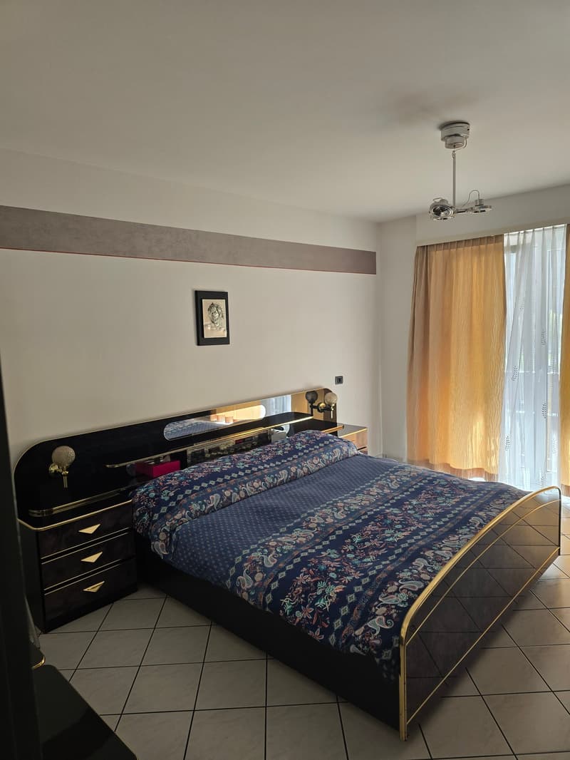 Bedroom with a bed, nightstands, and a picture frame on the wall