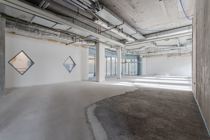 empty room, concrete floor, grey walls, square openings, glass doors, duct work