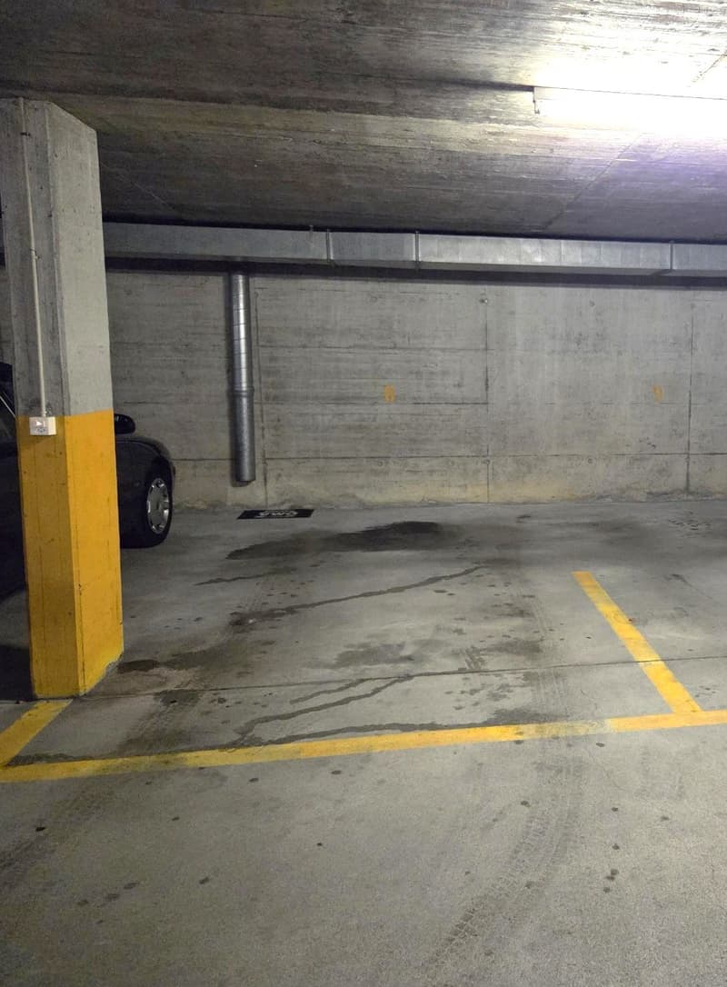 empty parking garage with yellow parking lines and pillar