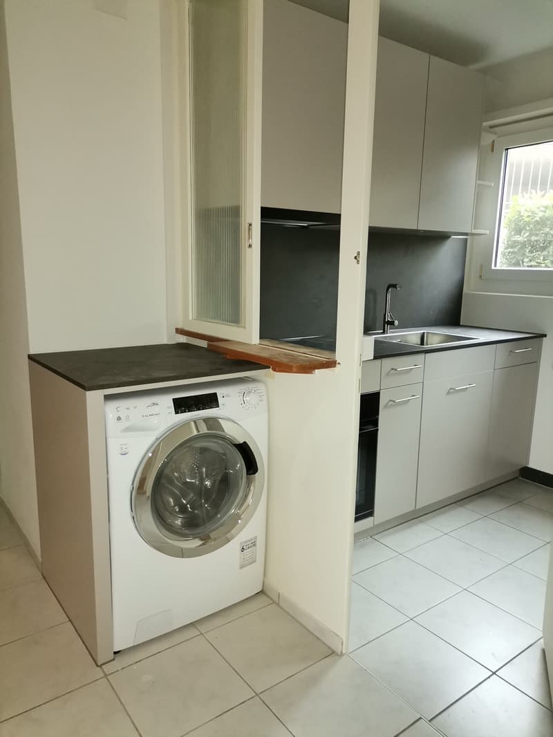 modern kitchen with white cabinets, tiled floor, washing machine, sink, faucet, window