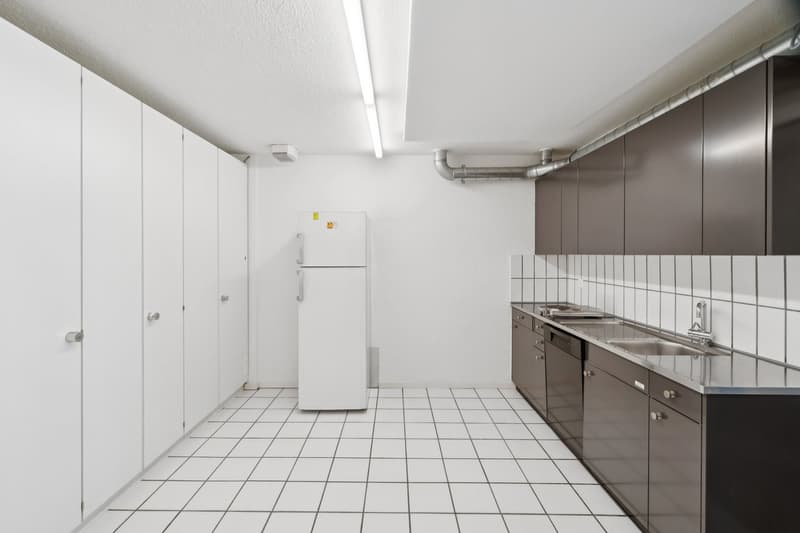 modern kitchen with white tiles, stainless steel countertops, white refrigerator, gray cabinets, sink, faucet, and dishwasher