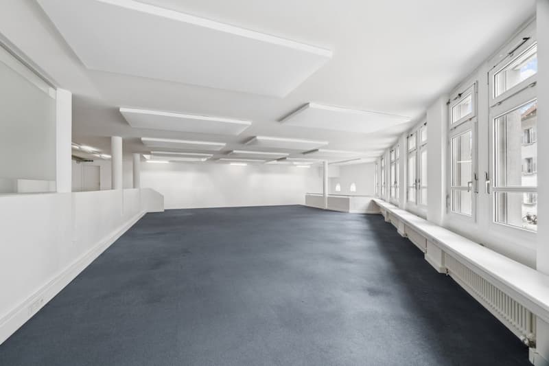 Empty room, white walls, gray floor, large windows, white ceiling, radiators