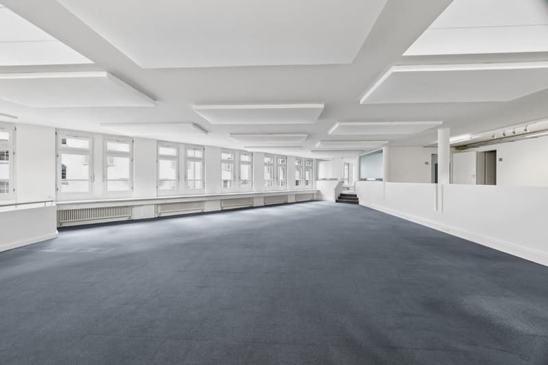 Empty room, white walls, gray carpet, large windows, white ceiling, radiators