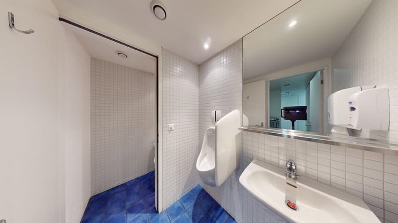 Small bathroom with shower and sink, white and blue tile