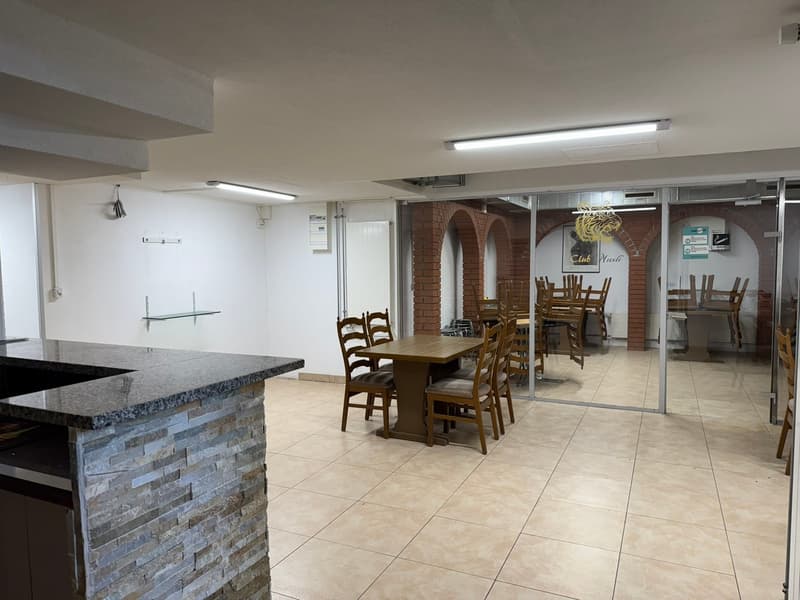 empty dining room with wooden table and chairs, granite countertop, tiled floor