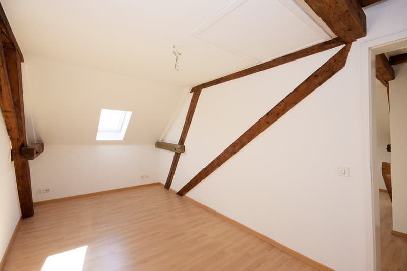empty room, wooden beams, wooden floor, white walls, small window
