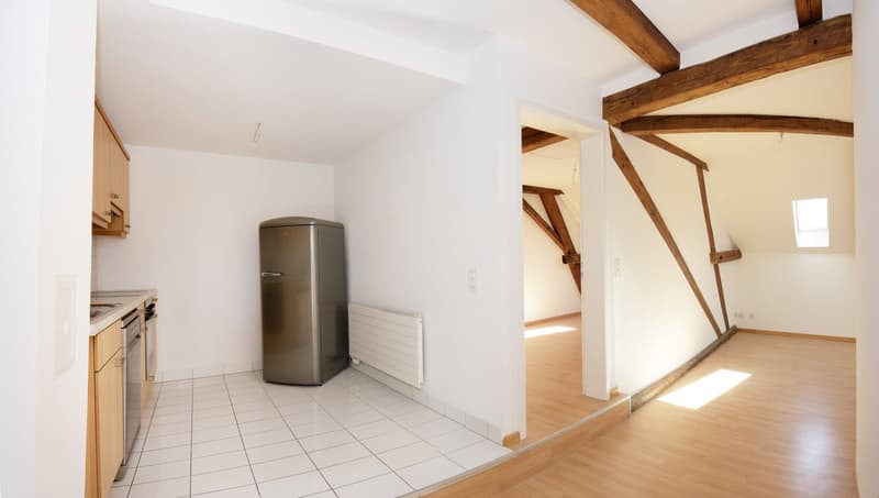 kitchen with white tiles, stainless steel fridge, wooden beams, white walls, white ceiling