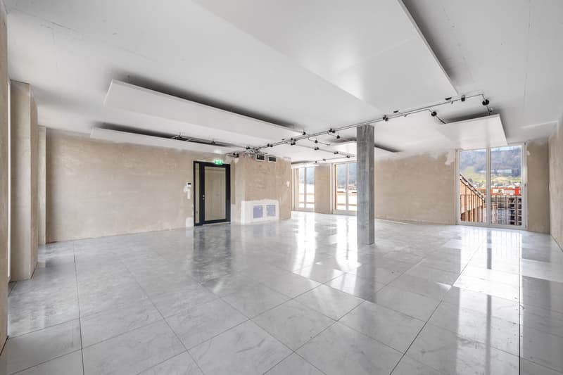 large open space, white tiles, industrial design, unfinished walls, large windows, large metal column