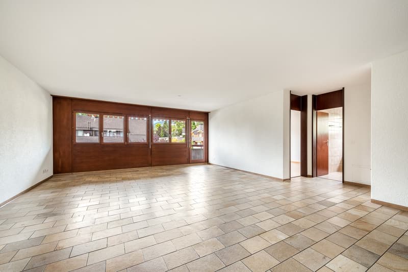 large empty room, wooden wall, tiled floor, windows