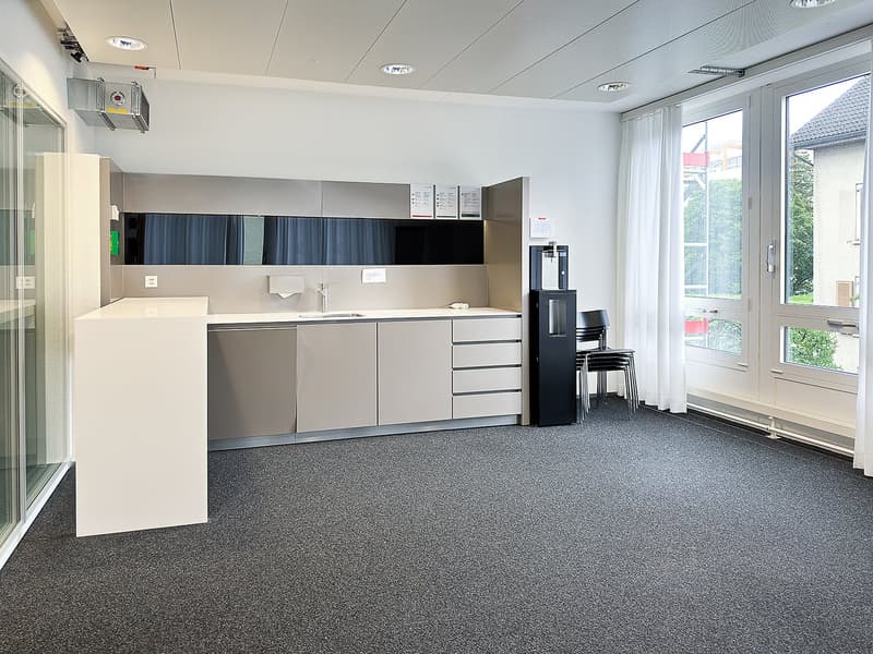 Empty room, modern kitchen setup, white countertops, built-in cabinets, black water dispenser, sink, faucet, and double doors leading to outside