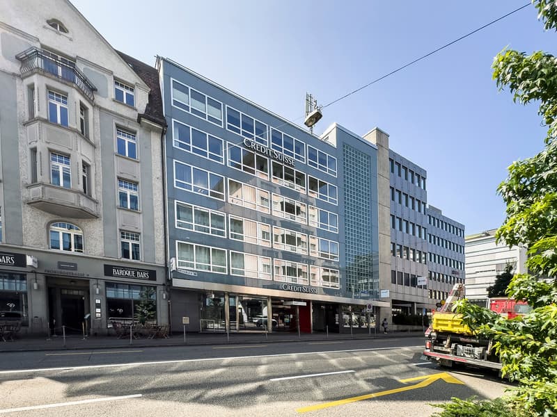 Office building with large windows, 'Credit Suisse' sign, modern architecture, located in an urban area