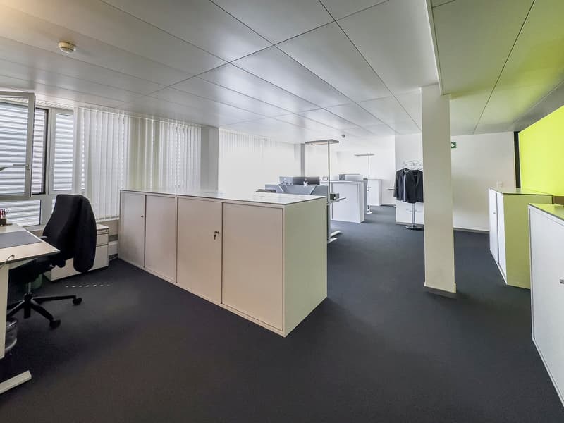open office plan, desks, monitors, cubicles, open shelving, bright colors, blinds, and carpets