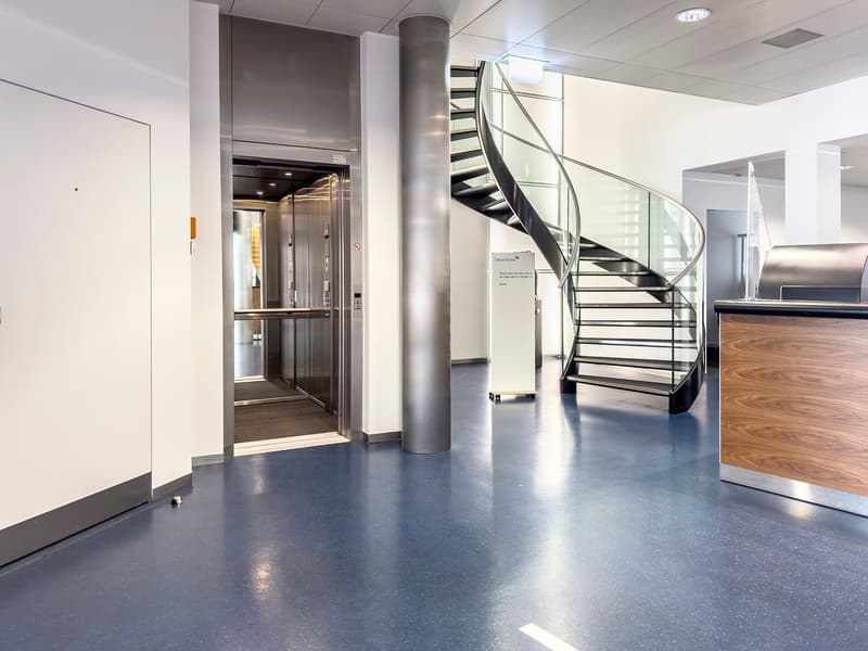 Elevator, staircase, modern and clean environment, blue floors, glass railings on stairs