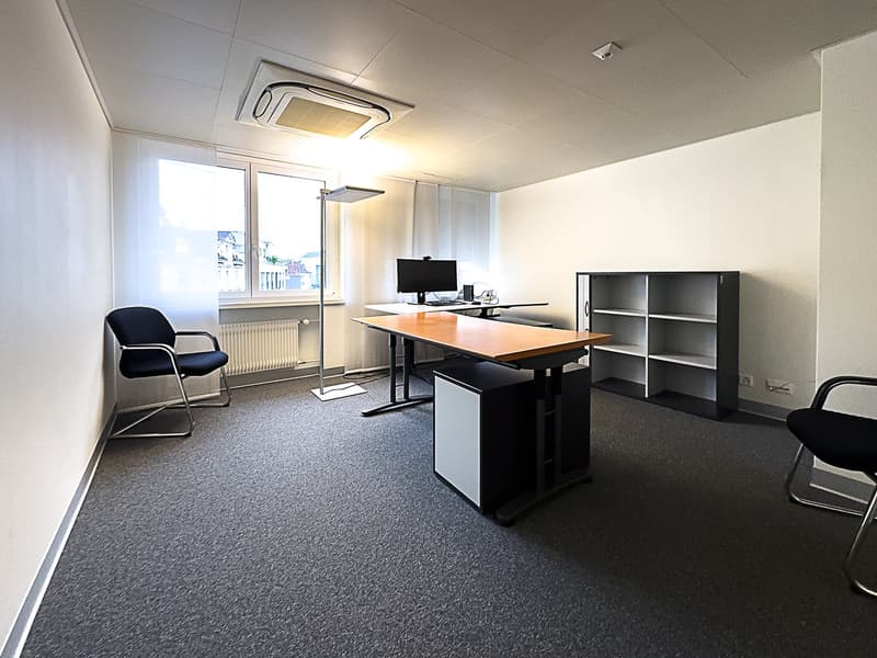Office room with desk, monitor, floor lamp, chair, shelves, radiator, floor