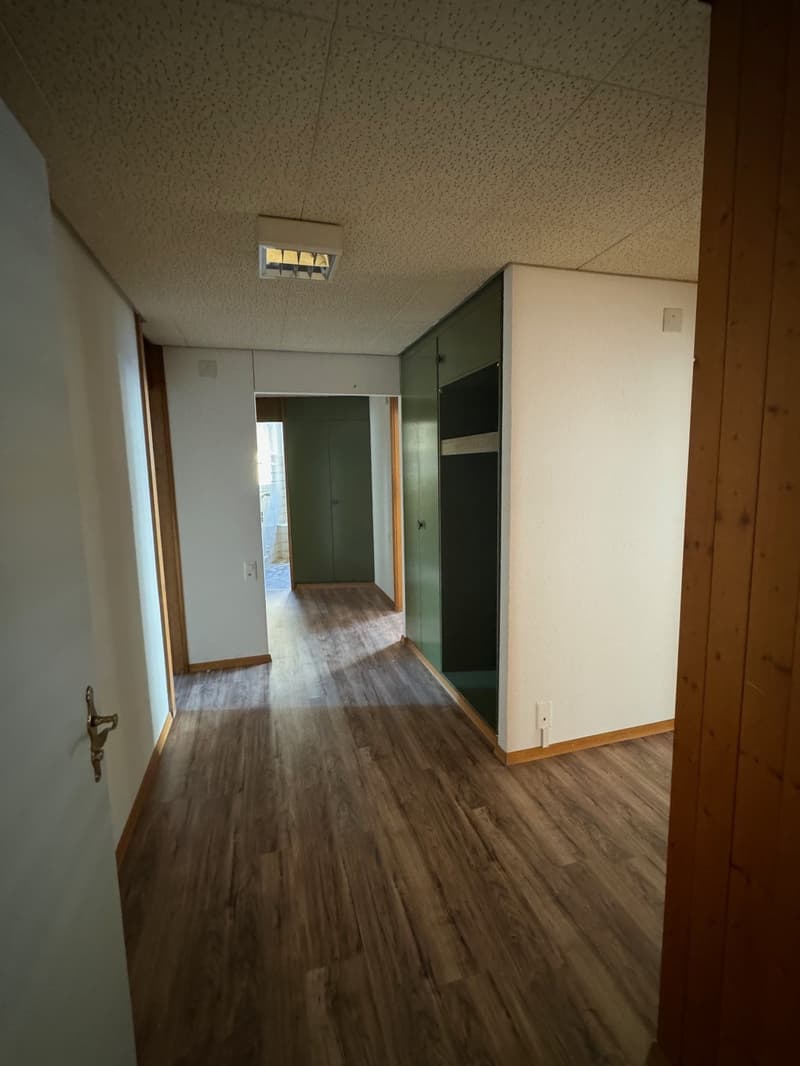 Empty hallway with wooden flooring and white walls