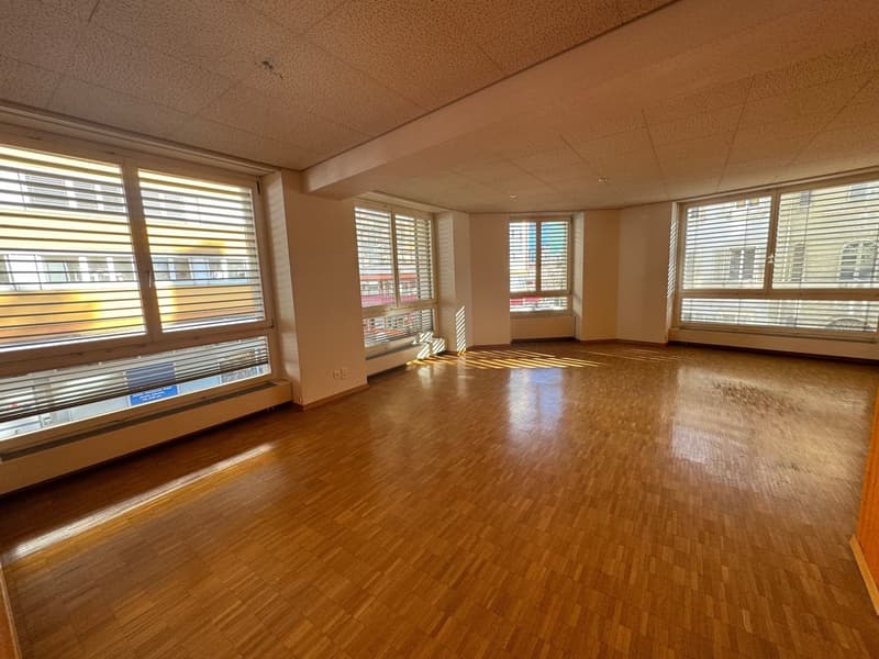 spacious room, wooden flooring, large windows, daylight