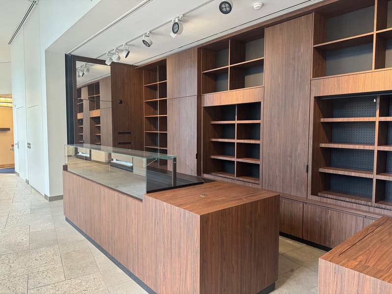 wooden cabinets, glass display case, tiled floor, track lighting
