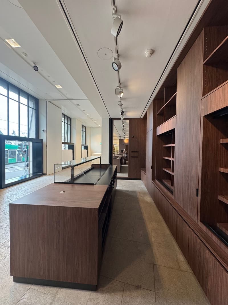 modern interior with wooden shelves, large windows, tiled floor, glass display case, ceiling lights