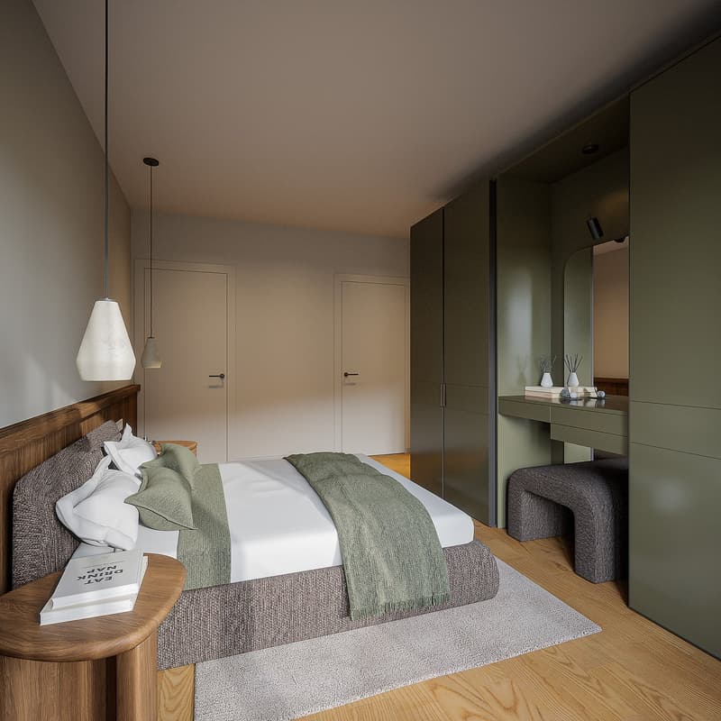 Large bed with grey bed cover, white pillows, wooden side table with book, wooden headboard, wooden flooring, white walls, green cupboards, mirror.