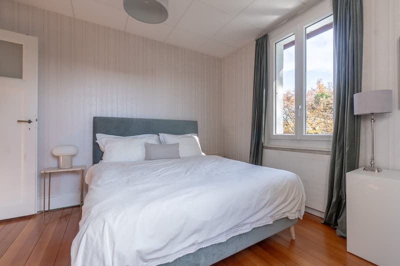 double bed, nightstand, floor lamp, radiator, window, gray curtains