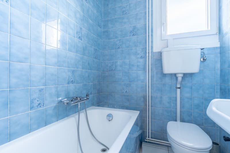 Bathtub, toilet, sink, blue tiles, silver fixtures