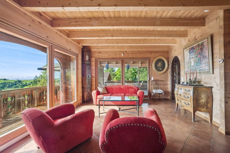 wooden interior, large windows, balcony, red couches, glass table, clock, picture frame