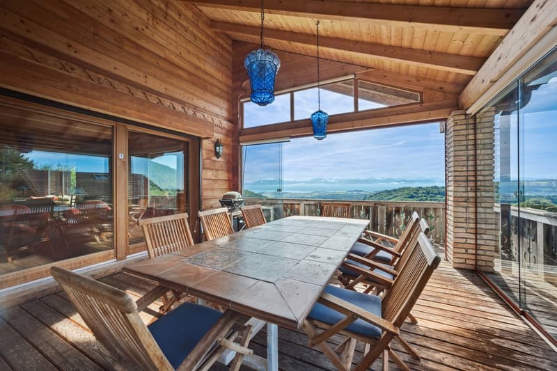wooden table and chairs on deck, panoramic windows, wooden ceiling, brick pillar