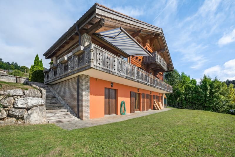 2 story house, wooden balcony, orange brick walls, brown wooden doors, large lawn, stone walls, steps