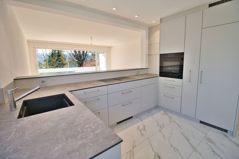 modern kitchen, white cabinets, marble countertop, stainless steel sink, built-in oven, large window