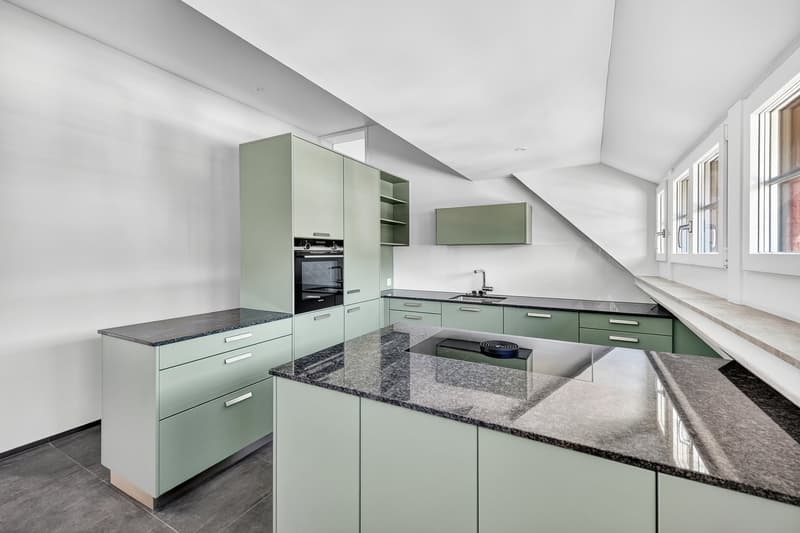 modern kitchen with green cabinets, granite countertops, built-in oven, sink, and faucet, large windows